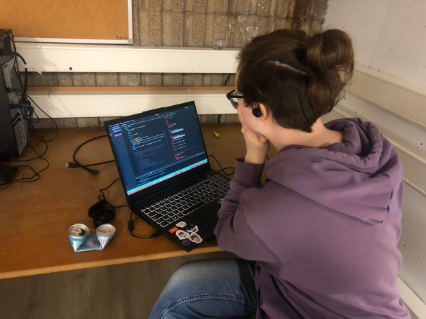 Amandine assise à un bureau devant son ordinateur portable, résolvant les problèmes de merge.